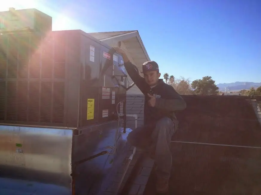 HVAC technician performing AC Tune-Up on a rooftop unit in Lawndale
